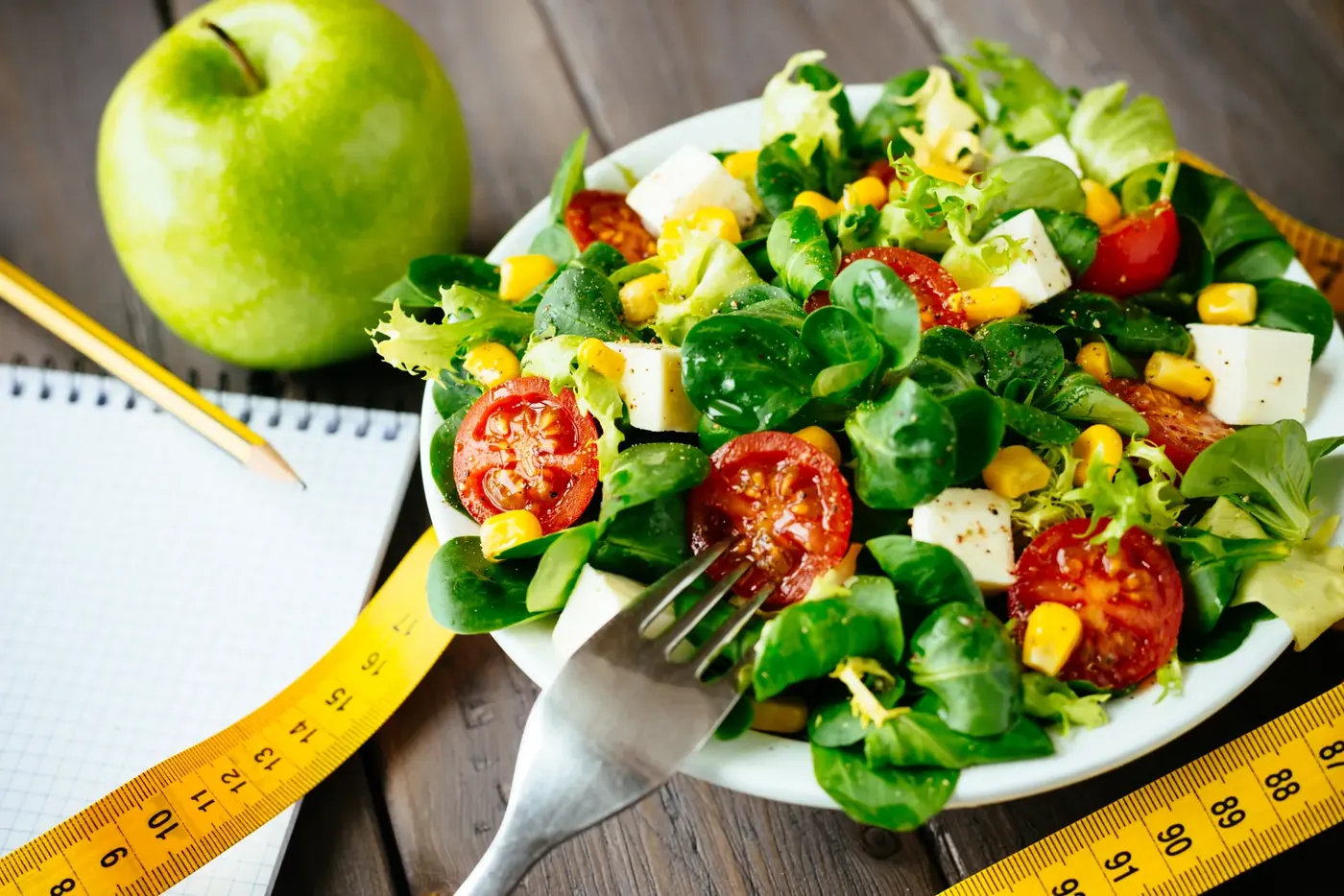 Healthy salad with apple and tape measure, illustrating ASA rulings on weight-loss medicine ads