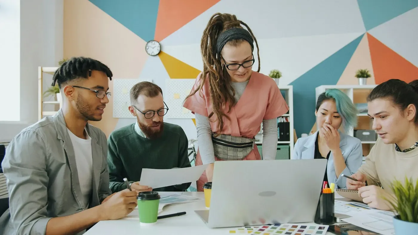 Brand team gathered around a laptop, checking campaign ads for compliance with Voxly Vision