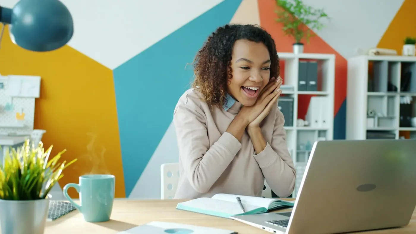 Brand manager smiling at her laptop after Voxly Vision cleared her ad for compliance