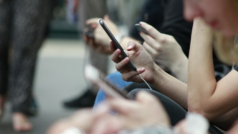 Commuters scrolling social media on their phones, the non-broadcast ads the CAP Code covers